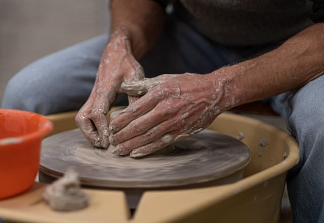 Keramiek workshops, persoon die pot op draai tafel maakt