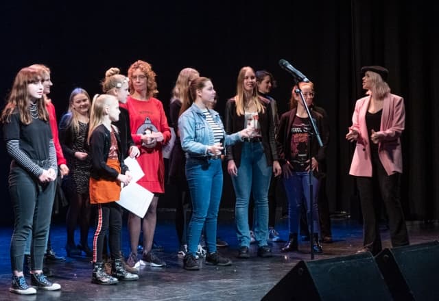 Zingen in een koor, jonge en oudere kinderen die op een podium zingen