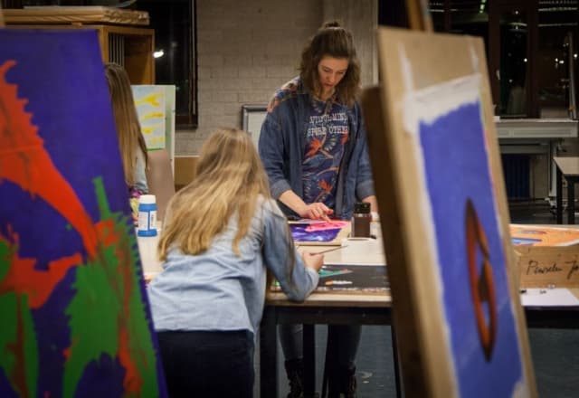 Twee jongeren die aan het schilderen zijn