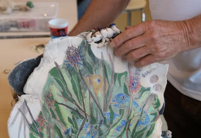Meneer bezig met de laatste details van zijn kermiek