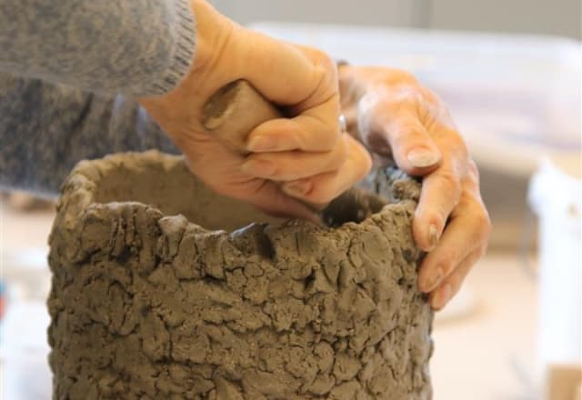 Persoon bezig met zijn keramiek