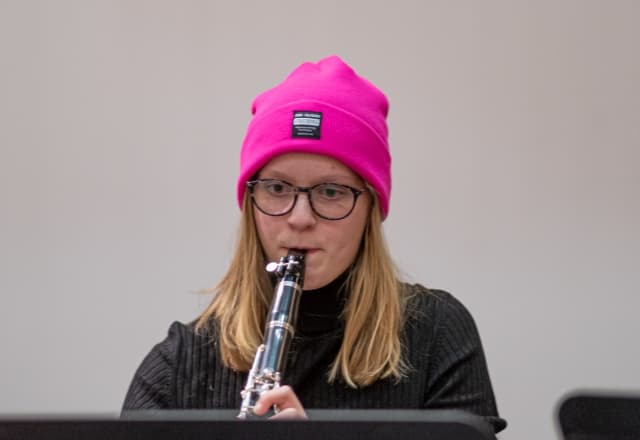 vrouw die kijkt naar haar noten en klarinet speelt