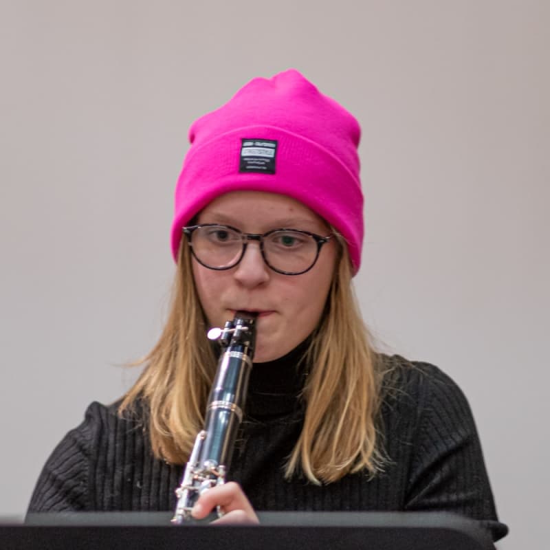 vrouw die kijkt naar haar noten en klarinet speelt