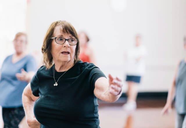 groepje mensen aan het bewegen en dansen met de armen