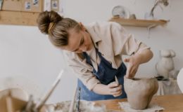 Vrouw die bezig is om haar keramiek in de goeie vorm te krijgen